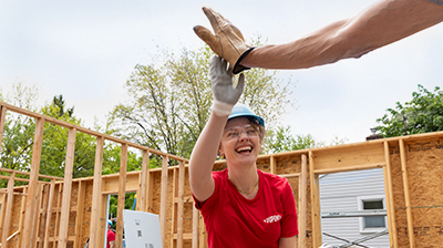 Habitat team members high-fiving at a home construction site